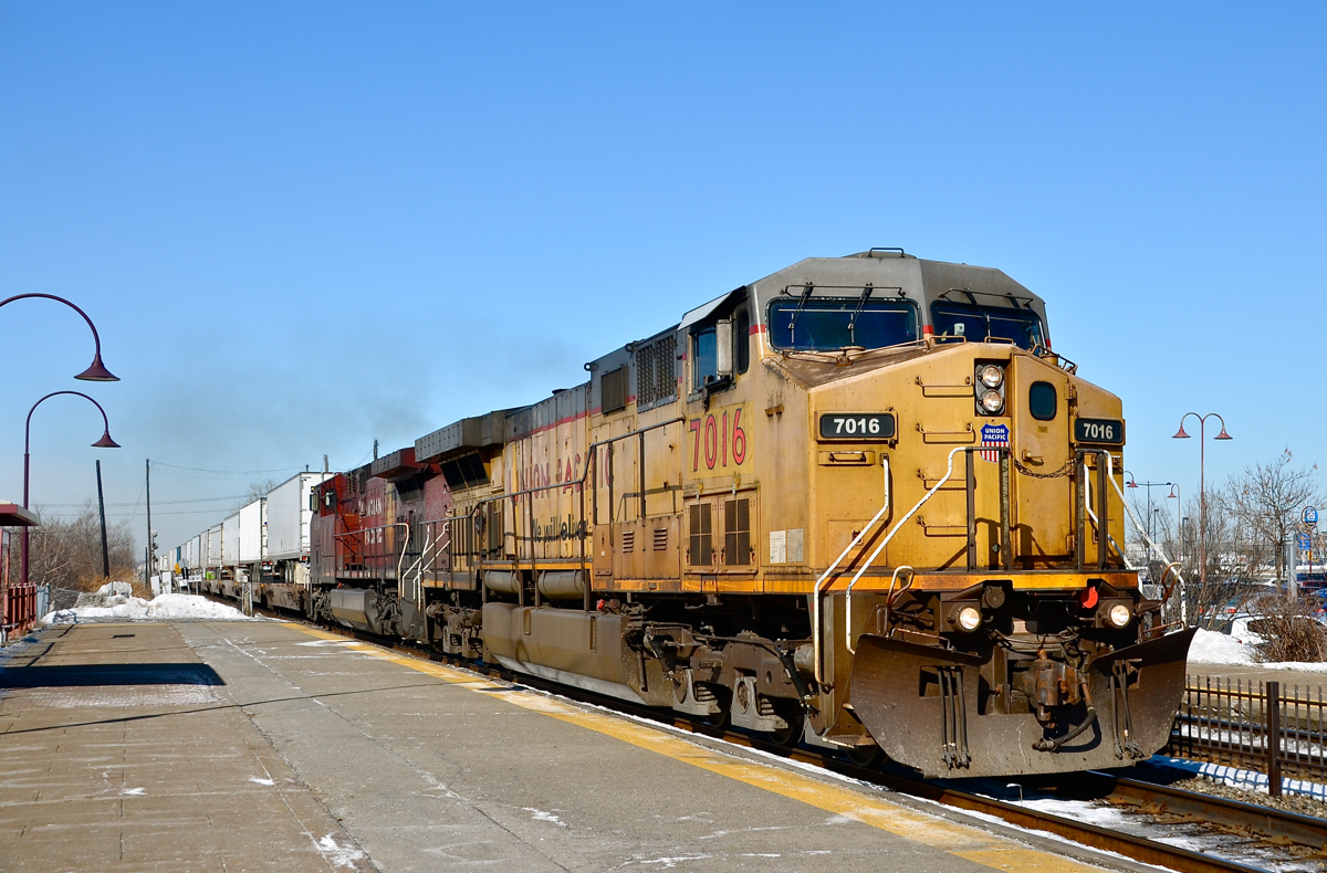 'We Will Deliver'..... even in Canada! Leased UP 7016 is seen leading another GE product (CP 9814) through Dorval with the eastbound Expressway (CP 132), a TOFC train between Montreal and Toronto and as far as I know the only dedicated piggyback train in all of Canada. It had sat just west of the station for about an half hour, awaiting a westbound AMT commuter train to clear. For more train photos, click here.