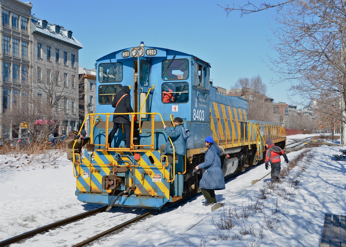 Full house! POM 8403 is stopped to participate in the Old Port Symphony, an annual event which involves boats, trains and church bells making a lot of noise and a number of participants are seen on the end cab of this MP15AC. For more train photos, click here.