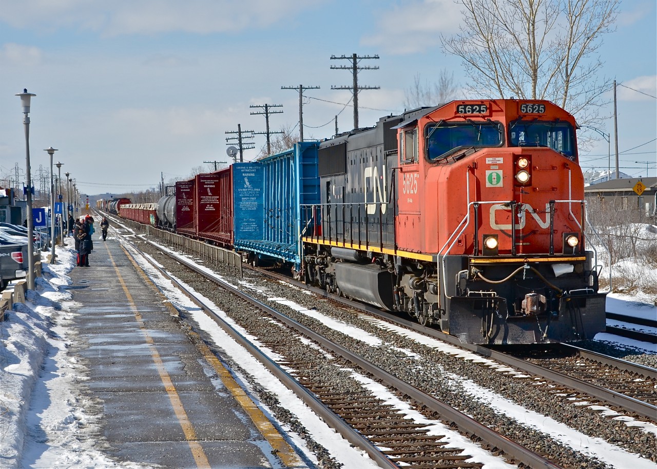 CN 372 heads east through VIA's Dorval station with a single unit as passengers await the arrival of VIA 65. For more train photos, click here.
