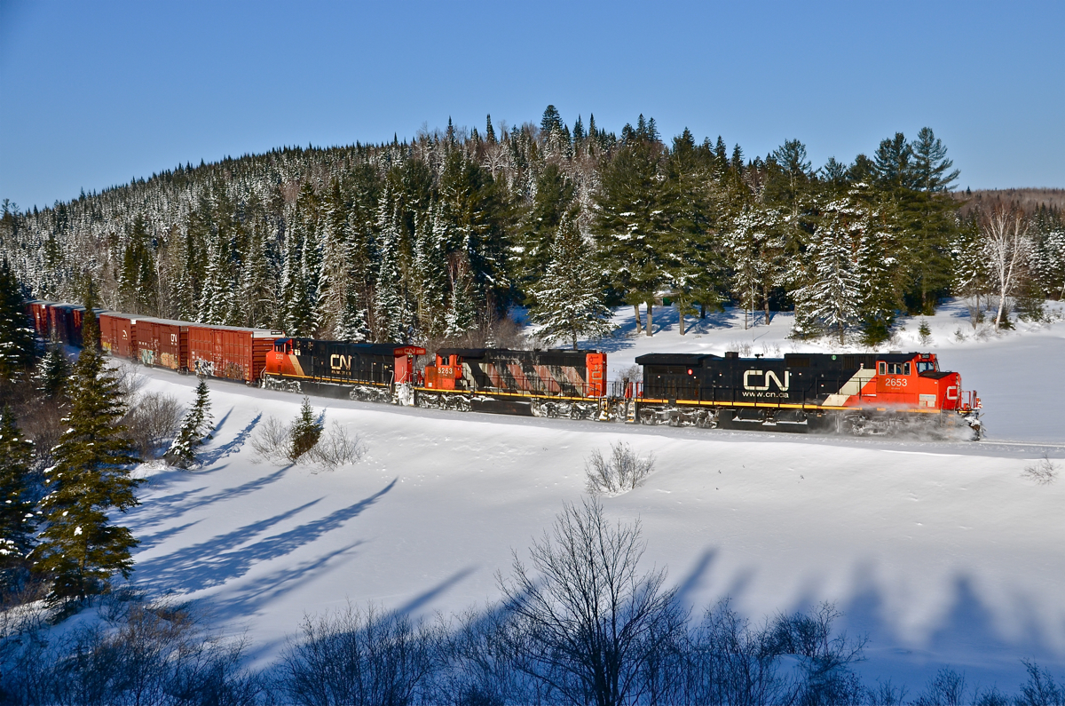 CN 2653, CN 5263 and CN 2322 are eastbound with CN 368 on the scenic Lac St-Jean sub on a beautiful but frigid morning. The train is passing through the scenic s-curve at milepost 37. For more train photos, click here.
