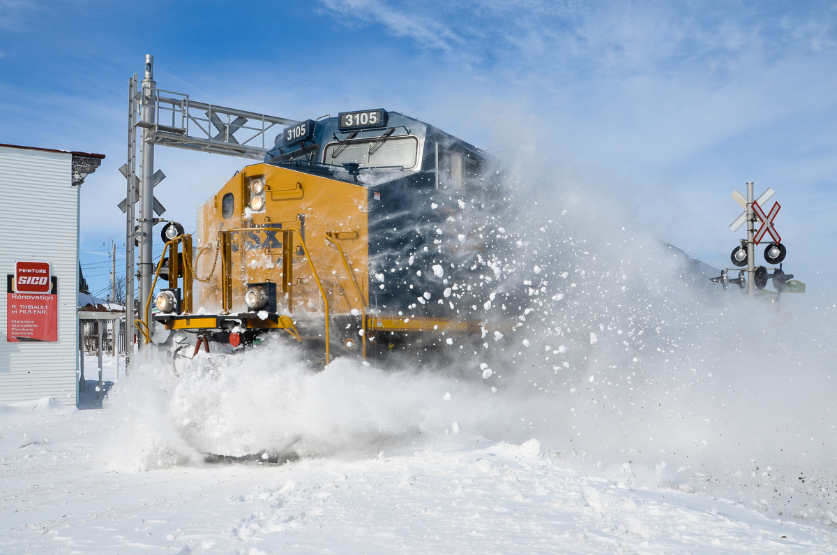 Snow bank busting! CN 327 (with CSXT 3105 and CSXT 867) heads south towards Huntingdon, passing through the town of Saint-Stanislas-de-Kostka and sending the snow flying at a crossing. For more train photos, click here.