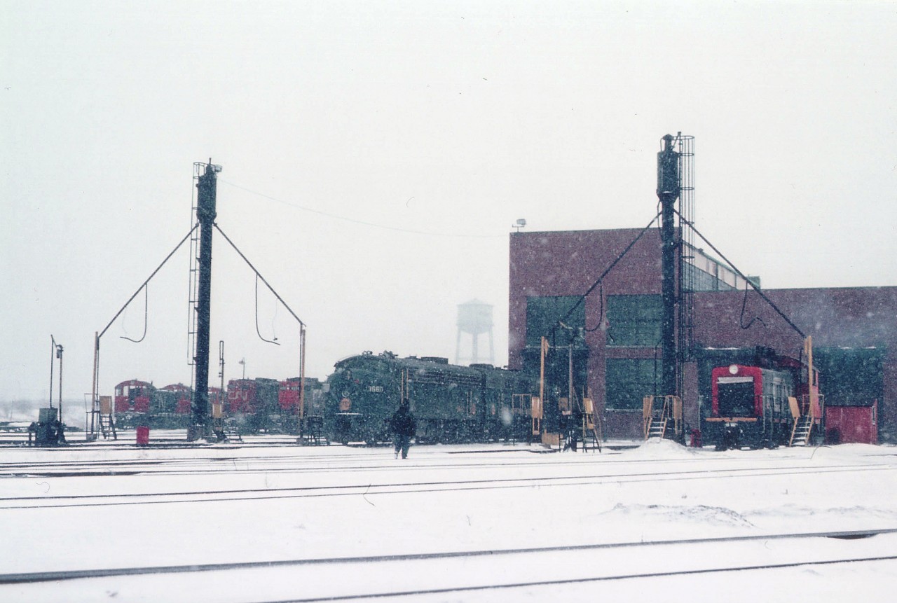 Stopping by the Fort Erie CN shop on a miserable cold snowy day in February, 38 years ago as this is posted, one can see a variety of units, mostly switchers and GP9s. The only locomotive ID'd by number is that N&W F unit facing outward, the 3660. I didn't jot numbers back then, however it is unusual that all the heavy road units are out, unless there are a couple on the close track behind the N&Ws. Hard to believe such a scene was commonplace. There even were rather substantial locomotive repairs carried out here. Now, a struggling Rail Museum has taken foothold in the old shop building after the facility sat empty for many years. CN pulled out around 1989.