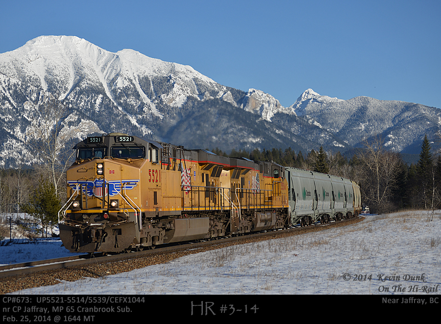 In the glow of afternoon sunlight, CP potash 673 pulled by UP 5521-5514 with mid-train DPU UP5539 and rear DPU CEFX1044 glide past the 65 mile board on CP's Cranbrook Sub under the watchful gaze of the Canadian Rockies.