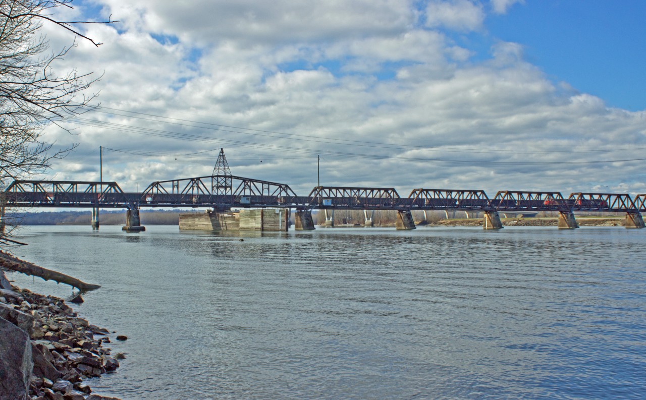 Empty C.N.R. sulphur train northbound over Fraser River on C.P.R Mission Bridge.  Will travel eastbound along Fraser and Thompson on shared trackage on C.P.R. mainline.