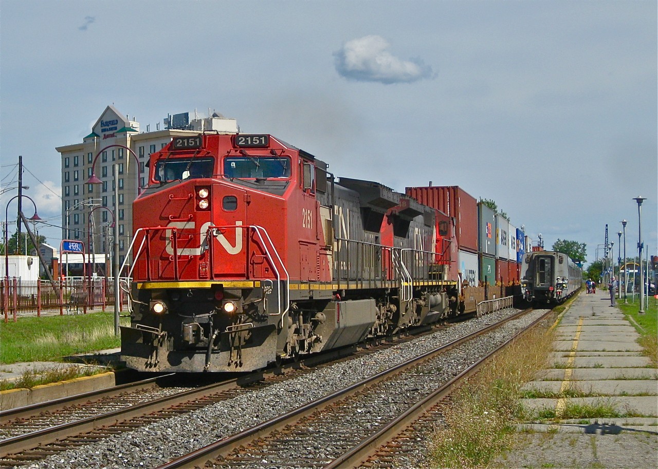 CN 2151 & CN 2148 (both ex-ATSF Dash8-4CW's with split cooling radiator modifications) head west through Dorval, Qc with CN 149. They are passing VIA 56 making its station stop.