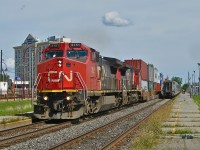 CN 2151 & CN 2148 (both ex-ATSF Dash8-4CW's with split cooling radiator modifications) head west through Dorval, Qc with CN 149. They are passing VIA 56 making its station stop.