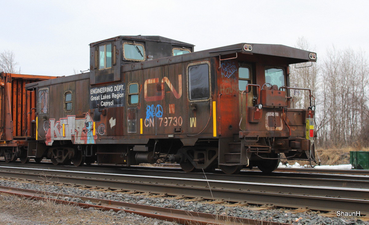 CN 900 rail train backs up passing the Cobourg Station with a ugly looking caboose !