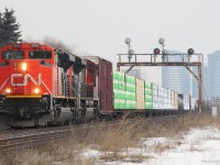2 "beast" SD70M-2's pull a westbound mixed freight past the New Westminster Dr underpass. In the background is an old signal bridge on the approach to Snider junction and further is two recently built condo's in North York, ON.