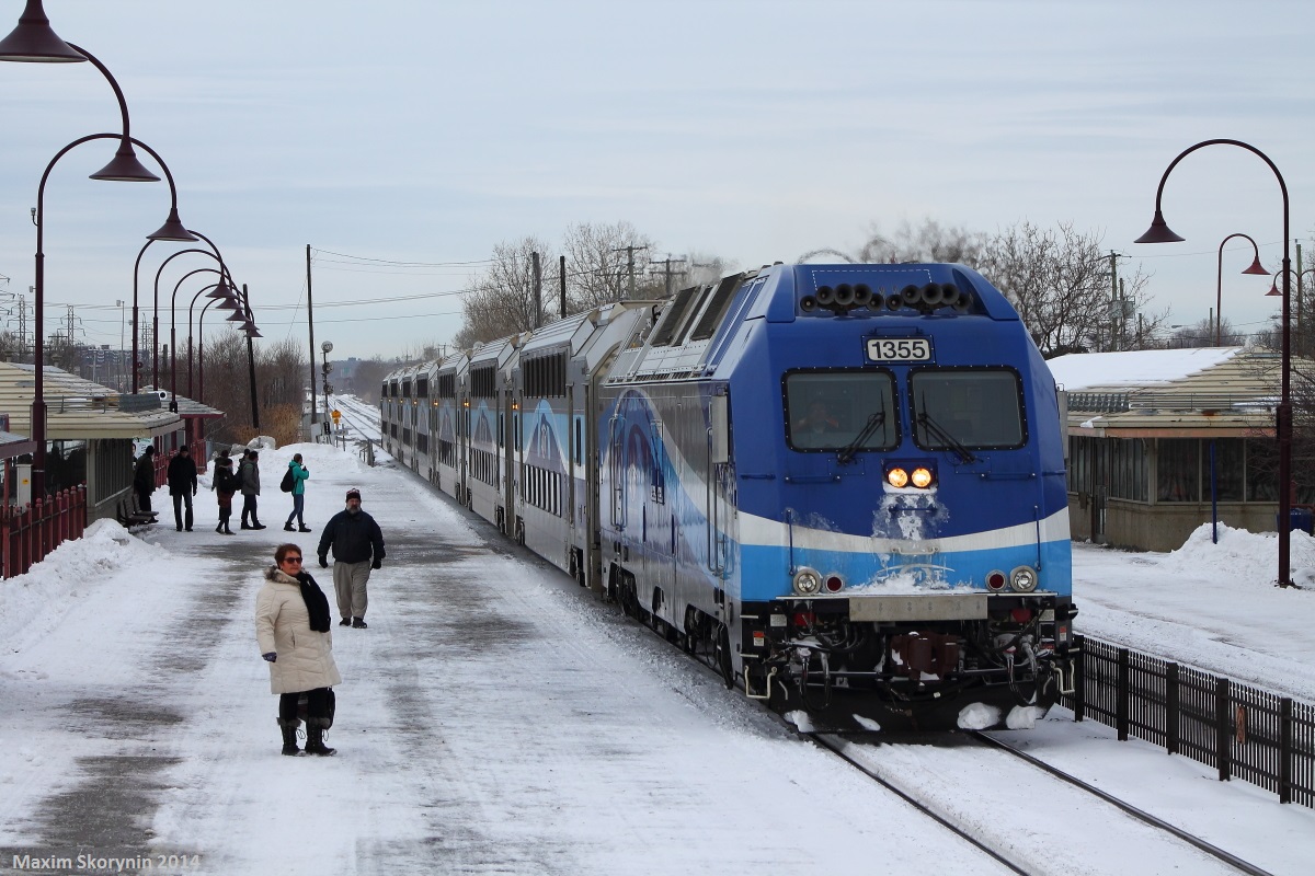 Montreal bound AMT train stops at Dorval station picking up commuters to deliver them to downtown, with a decent looking engine up front.