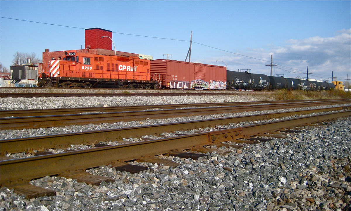 The Dorion Turn is stopped at Dorval; soon a westbound with CP 8775 & CP 9561 will blow by with a long string of intermodal cars. The consist is a GP9 (CP 8228), 5 cars and a caboose (CP 434957). In the foreground is CN's parallel Montreal Sub and the CN/CP interchange track (since removed and relocated a few miles west). For more train photos, click here.