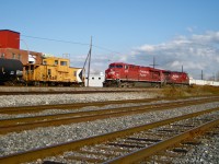 <b><i>Modern railroading blows by the old.</i></b> Representing modern railroading, a CP westbound with two modern, widecab GE's (CP 8775 & CP 9561) and a long string of intermodal cars blows by a caboose (CP 434957) which is stopped and at the tail end of the Dorion Turn which has a GP9 (CP 8228) and 5 cars ahead of the caboose. For more train photos, click <a href=http://www.flickr.com/photos/mtlwestrailfan/>here.</a>