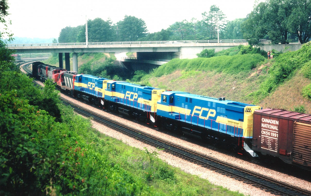 Impressive trio of new Mexican locomotives trailing 4 CNs; so impressive I missed the CN numbers...up front CN 9619, 9xxx,9663, 45xx and FCP 575, 573 and 574. These newbies were built by Bombardier, M424W models, for Ferrocarril Del Pacifico. The FCP was absorbed into NdeM in 1985; and these units delivered in blue/yellow instead of the NdeM red/green. The Farrocarrilles Nacionales de Mexico was state owned until 1998, then privatized and broken up. One must remember, this was the days before internet, and information was nowhere near as plentiful and available as it is today. Seeing these roll by was a complete shock.