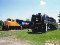 The Old and the New. On the longest day of the year with the sun up high and hot, we see the brand-new $2.8M ONR SD75I #2100 on display for all at the Englehart station and head office. John Thib, I believe ONR General Manager at the time, ushered me aboard to have a look around. Nice, but for all that money one would think it would come with hotplate AND air-conditioning..NOT a choice of either. This new on the scene locomotive was parked next to the T&NO (Temiskaming & Northern Ontario) #701, maintained in pristine condition with pride as a tribute to the very last steam engine that ran on these rails, retiring to display after the June 25, 1957 farewell. The engine began life as #158 in 1921, then to #758 in 1935, and #701 in 1940. Oddly enough, in retirement it ended up outlasting the ONR 2100, which was wrecked April 12, 2011 and subsequently mothballed.