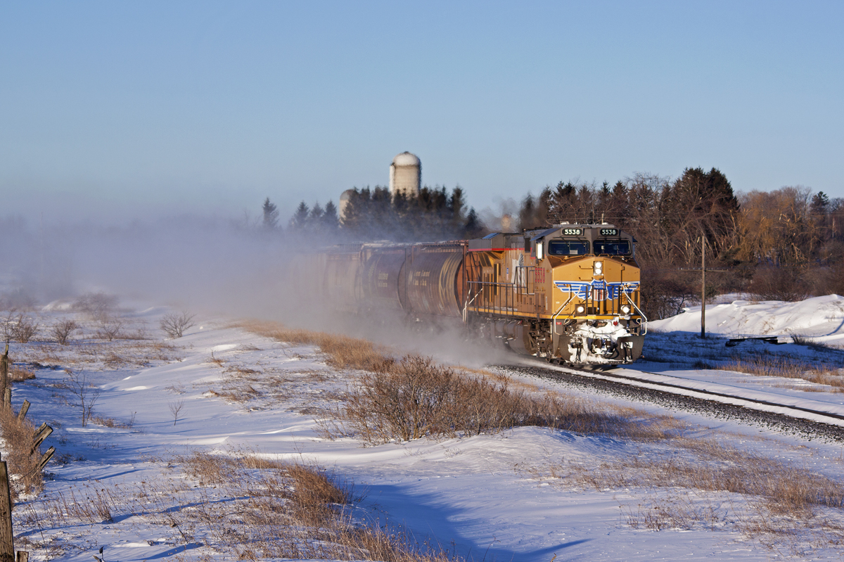 FPON! UP 5538 charges east just after sunrise with grain loads destined for Quebec.
