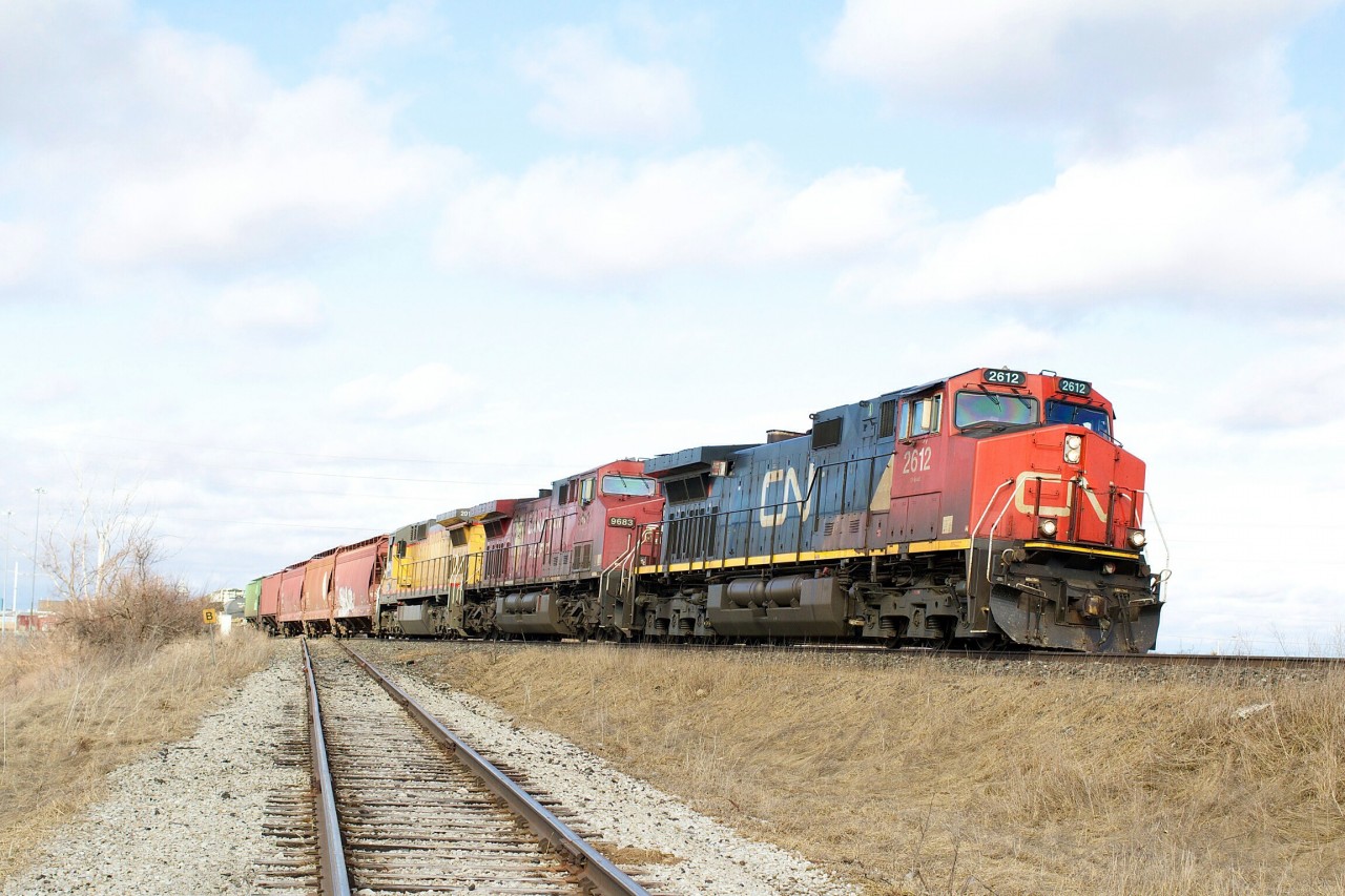 A colourful CN 399 with CP 9683 and CN 2014 on UP yellow trailing passes the glass lead at milton.
