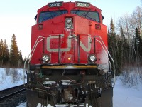 Stopped in the siding at Kukatush, waiting for an eastbound.  

Notice on the left side below the ditchlight:  That green stuff is granulated automotive glass.  This train was involved in a (non fatal) grade crossing accident south of Brechin East.  There was a bunch of glass and tail lights stuck between the plow and pilot as well.