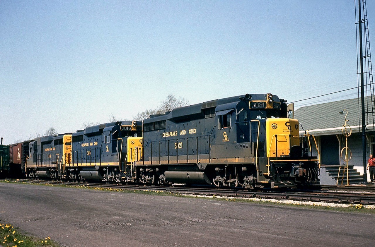A nice 3-pack of Chesapeake and Ohio GP30's poses by the station at Merlin ON (west of Blenheim) in May of 1964. Less than a year old, C&O 3021 leads the pack, with 3016 and another matching EMD sister as they wait at the station to meet a westbound on C&O's Subdivision 1.  Note the train order hoops in front of the station, the upper one for the crew in the cab, the lower one for the crew in the caboose to grab their orders from. Canadian railways have typically favoured hand-held train order hoops, as opposed to the ground-mounted ones shown here.