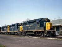 A nice 3-pack of Chesapeake and Ohio GP30's poses by the station at Merlin ON (west of Blenheim) in May of 1964. Less than a year old, C&O 3021 leads the pack, with 3016 and another matching EMD sister as they wait at the station to meet a westbound on C&O's Subdivision 1.  Note the train order hoops in front of the station, the upper one for the crew in the cab, the lower one for the crew in the caboose to grab their orders from. Canadian railways have typically favoured hand-held train order hoops, as opposed to the ground-mounted ones shown here.