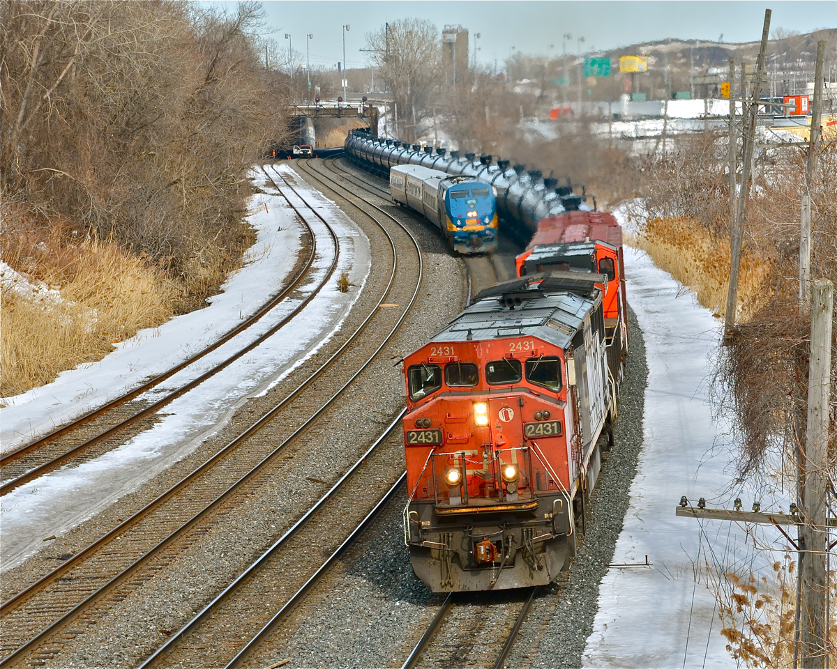 2 trains and 1 hi-railer At far right on the south track is CN 711  with CN 2431 and CN 2657, departing Turcot West after changing crews. To the left is VIA 57 with VIA 918 leading three LRC cars. Further to the left is a CN hi-railer, stopped on the freight track. For more train photos, click here.