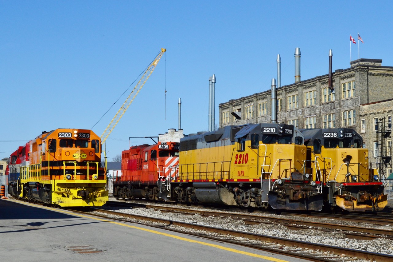On an April Sunday morning ten minutes after 84 departed,


see:

  train 84   


 the GEXR rolls into Kitchener.


The six GEXR units are an interesting mix:


from the left and the (barely visible ) trailing unit #3821 (plain GP 38 EMD 11/1967, ex Salt Lake Southern) in red, grey with white stripes;


Middle unit RLK #4095 (GP 40 EMD 6/1966) in red, silver and blue;


Lead unit GEXR 2303


and in the overnight storage tracks: 


ex CP GP 9u  8235 (nee CP 8822 GMD GP9 1958 )


LLPX 2210 (GP 38AC EMD 11/1971, nee GTW 5806)


LLPX 2236 ( GP 38-2 EMD 2/1976, nee LIRR 262)


The crane in the background is part of the new (Weber Ave) underpass construction.


April 6, 2014 image by S. Danko.
