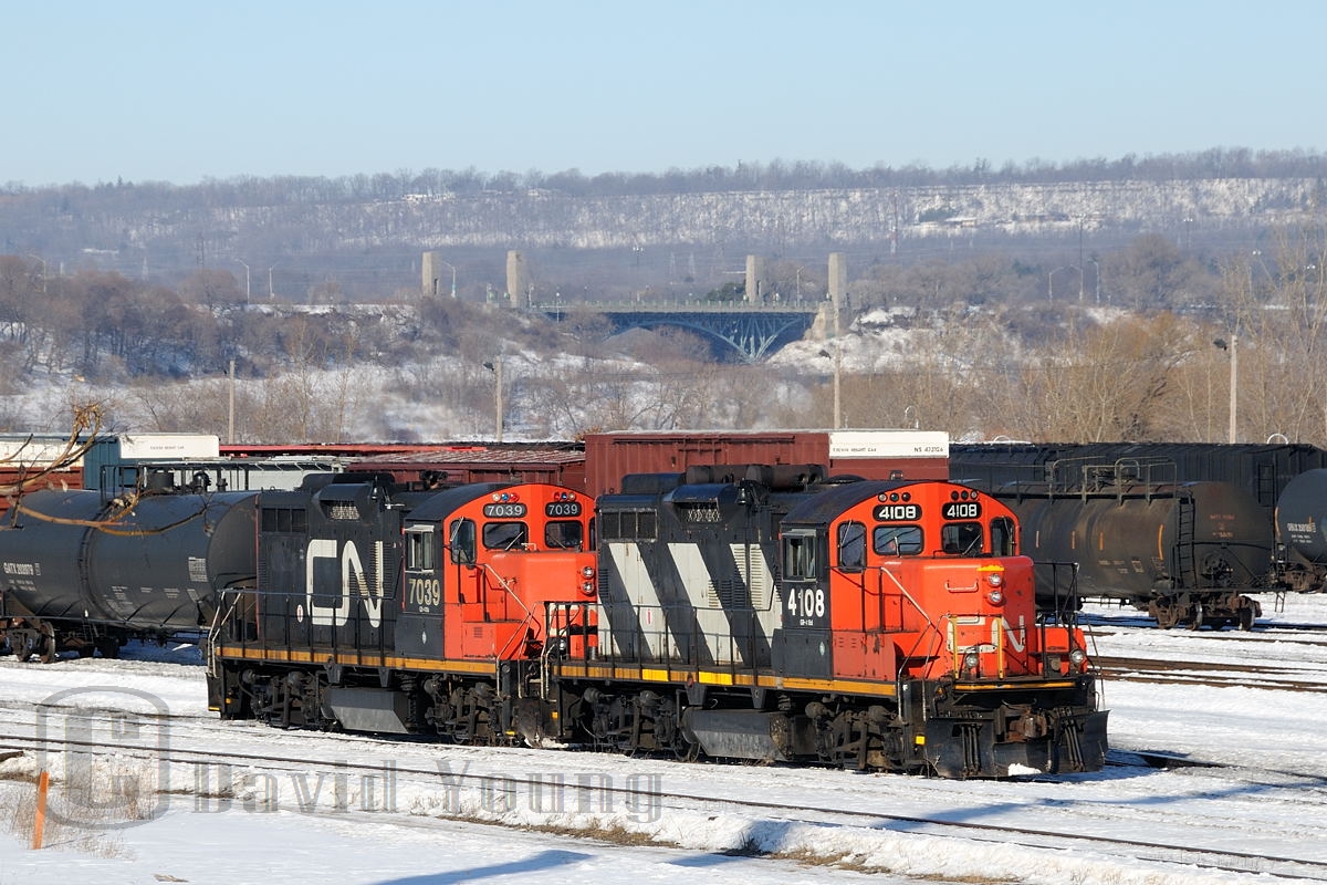 CN GP9RM's 4108 and 7039 back towards their train of "bottles" on a beautiful winter's day in Hamilton. Due to Stelco(?) shutting down their Hamilton facility (which would be temporary), they would move three "hot bottle cars" to Nanticoke along with one of their engines No. 85. The hot bottle cars were heavy and 5 "idler's" were required between them. The move was run between CN and SOR crews. The train would back thru Bayview and head west up the Dundas with these CN units leading to Brantford. More photo's of this unique move will follow.