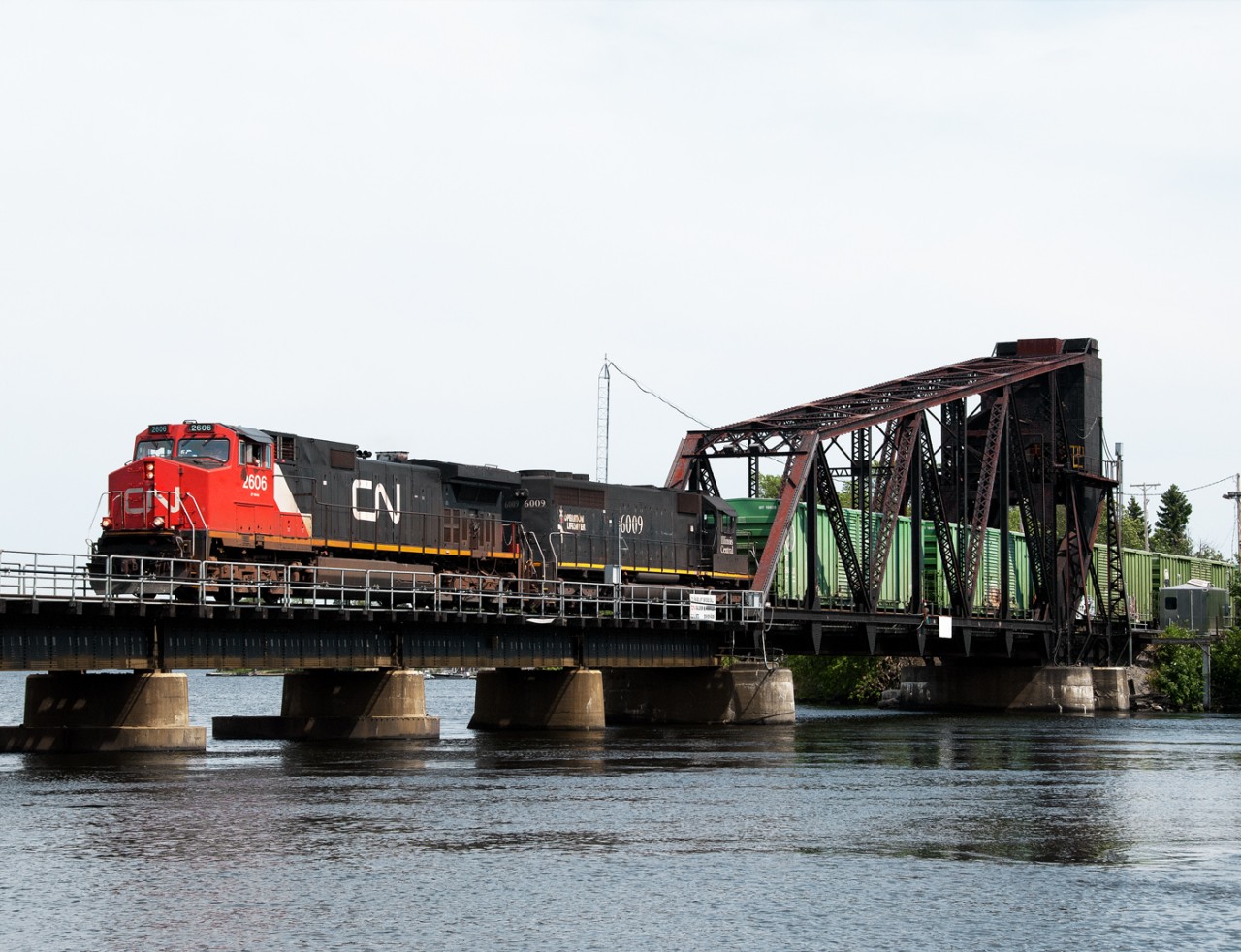 CN train 347 has just departed Ranier Minnesota and crosses the International Bridge over the Rainy River on the east side of Fort Frances. This is the second busiest international rail crossing after Sarnia - Port Huron.