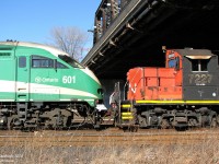 <b>Young Beauty and an Old Beast.</b> <br><br> By some odd coincidence, this happened: a brand new GO MP40 (perhaps being picked up from Mimico for some warranty work in Welland?) coupled backwards on the head end of a work extra powered by a CN GP9RM and slug, with a ton of ballast hoppers and boxcars behind, sitting in the Union Station Rail Corridor in the afternoon. <br><br> I'm not sure what they were doing there, or why GO 601 was leading rear-end-first, but seeing it from the Gardiner Expressway was enough for me to walk from Union Station to Bathurst Street to get some photos. The train wasn't positioned well for shots from the bridge above, but the Fort York area to the west was open and working around the high chain-link fence, a few shots were had of this odd lashup. <br><br> The streamlined MPI MP40PH-3C was built in Boise ID for GO Transit commuter service a few years ago. The utilitarian GM GP9RM, 7227, was built as CN 4563 in the 50's and was likely pressed into passenger service with steam generator cars a few times before being rebuilt for yard service in the 80's. The torch has been passed, but the 7227 will probably get the last laugh: I can't see MP40's surviving in 50 years downgraded to freight service.