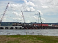 Northbound B.N.S.F. mixed freight on Mud Bay trestle, Surrey, B.C.  Work in progress of major upgrade of trestle from wood to concrete. 