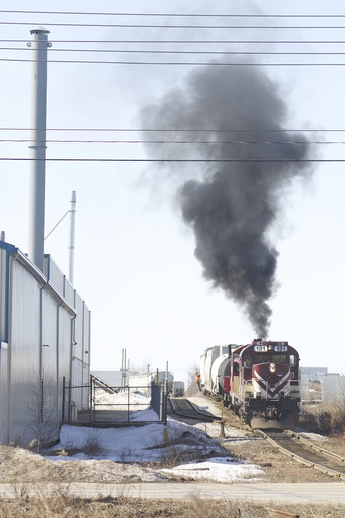The Guelph Jct. Railway is putting on a nice show as RS18 181 and SW1200 1210 back their train down the spur to the Bi-Pro facility. These tracks are shared with the Goderich-Exeter RR. A track mobile has also just cleared into the facility in the background.