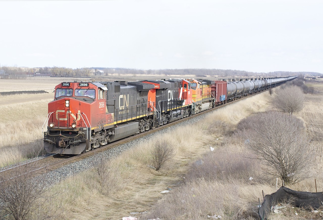 A trio of General Electric built units including CN 2696, 2845 and BNSF 5367 have an ethanol train stretched out over the countryside south of Milton.