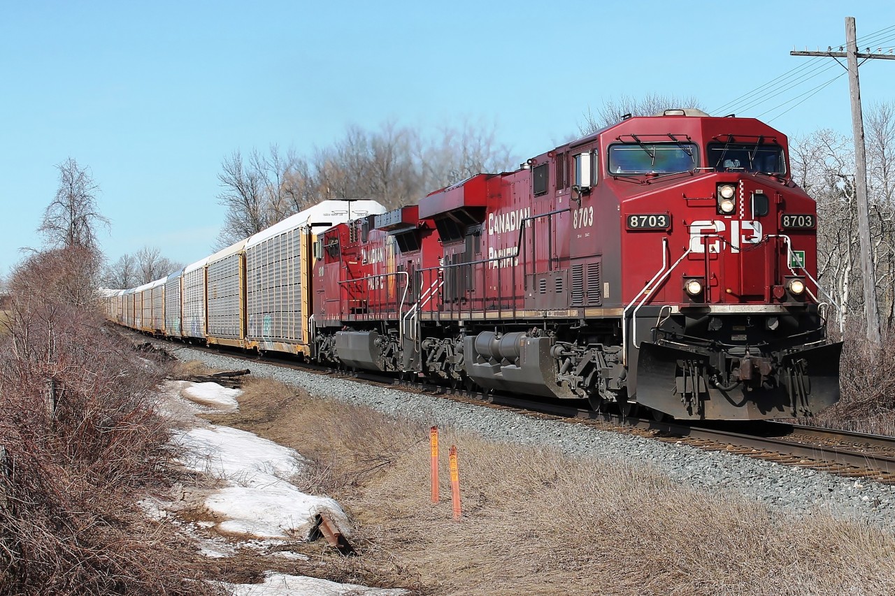Two CP GE locos 8703 and 9810 on 234- autoracks and intermodal heading east at Gobles Rd crossing. Visible, hopefully, the last signs of snow.