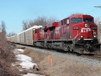 Two CP GE locos 8703 and 9810 on 234- autoracks and intermodal heading east at Gobles Rd crossing. Visible, hopefully, the last signs of snow.