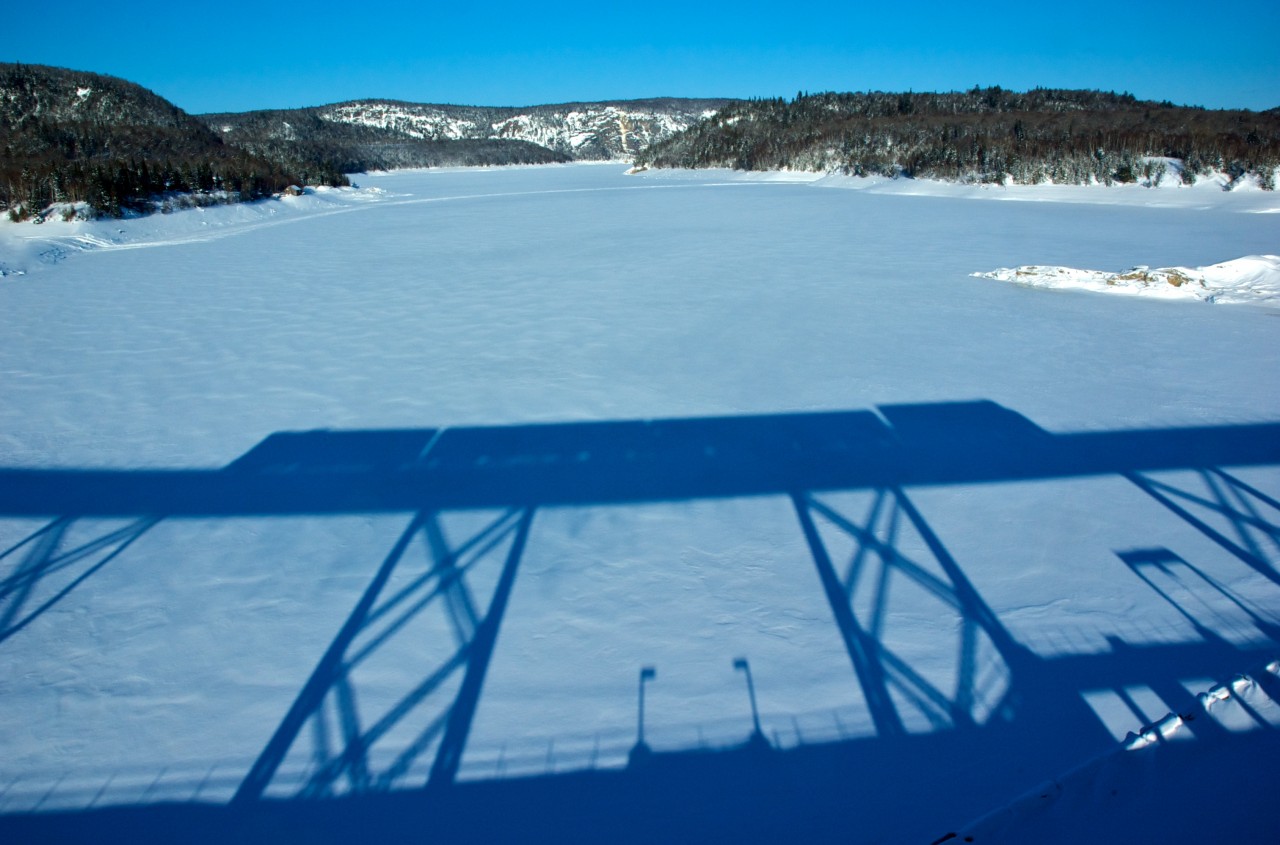 Shadow of the Southbound ACR Passenger train on the Montreal River trestle.  The cliff in the background is part of JEH MacDonald's "Solemn Land"