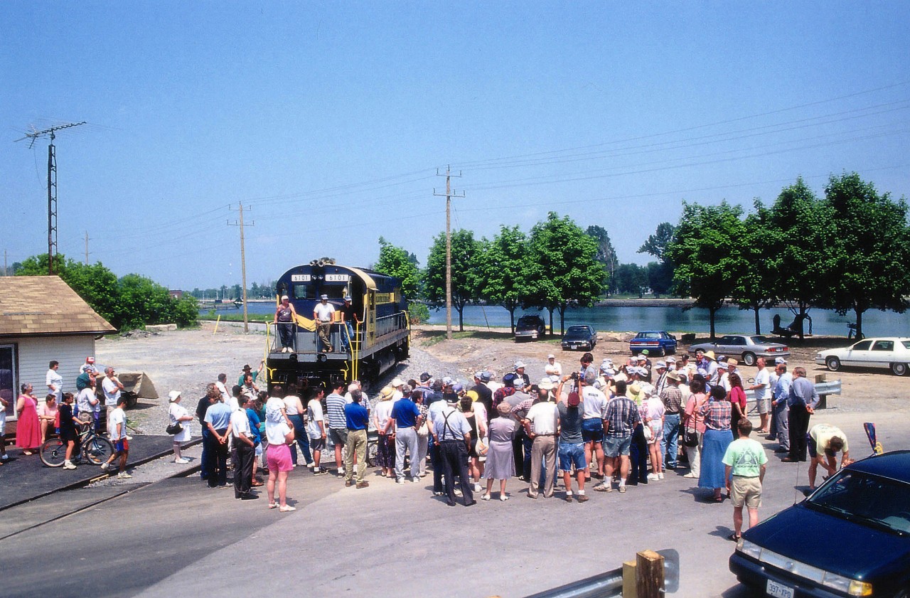 We saw photos of the demise of the St. Thomas & Eastern last winter, one of the 3 lines that made up the Trillium Rwy group. Here is a scene from better times, the very start-up of the Port Colborne Harbour Railway, which was the oldest of the shorts that became known as Trillium.
 The day of ceremonies was July 2, 1997, a blistering hot day wherein the locals forsook their coffee shops and backyard gardening in order to hear Prez Wayne Ettinger preach the promise of a new railroad in town. It is he in the cap and suit; no one else would be caught dead in a get-up such as that on a day that was in the 30C+ range. We are downtown, the old CN Port station is behind me and the canal is background to this photo. I might add there are a couple of "RPca'ers in the photo as well.  You know who you are. :o)