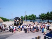We saw photos of the demise of the St. Thomas & Eastern last winter, one of the 3 lines that made up the Trillium Rwy group. Here is a scene from better times, the very start-up of the Port Colborne Harbour Railway, which was the oldest of the shorts that became known as Trillium.
 The day of ceremonies was July 2, 1997, a blistering hot day wherein the locals forsook their coffee shops and backyard gardening in order to hear Prez Wayne Ettinger preach the promise of a new railroad in town. It is he in the cap and suit; no one else would be caught dead in a get-up such as that on a day that was in the 30C+ range. We are downtown, the old CN Port station is behind me and the canal is background to this photo. I might add there are a couple of "RPca'ers in the photo as well.  You know who you are. :o)