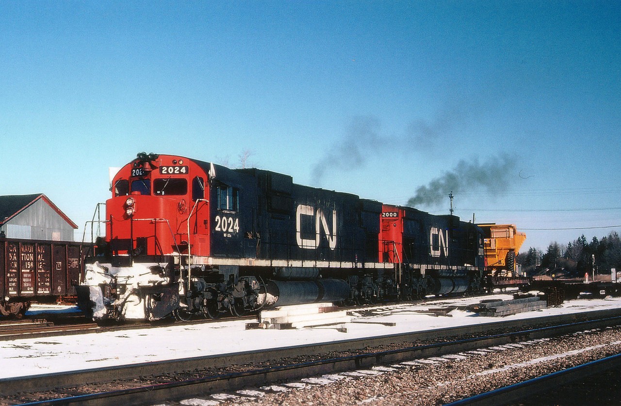 On the heels of Young Mr. Host's image at Paris Jct. is this shot of CN train #401, cutting off his train in order to pick up a piece of heavy machinery on a flatcar which awaited on a Paris Jct spur.  Power is CN 2024 and 2000. Train #401 was popular with the fans, as it backed out of Hamilton to Bayview Jct and awaited a signal in order to proceed west up the Dundas. Memory fails me on the Paris activity. Did the load come down from Goderich where Champion graders were built? The Drumbo Sub was still in place at this time. Anyway, a nice piece of history and comments and any information regarding activity at Paris Jct would be greatly appreciated.
