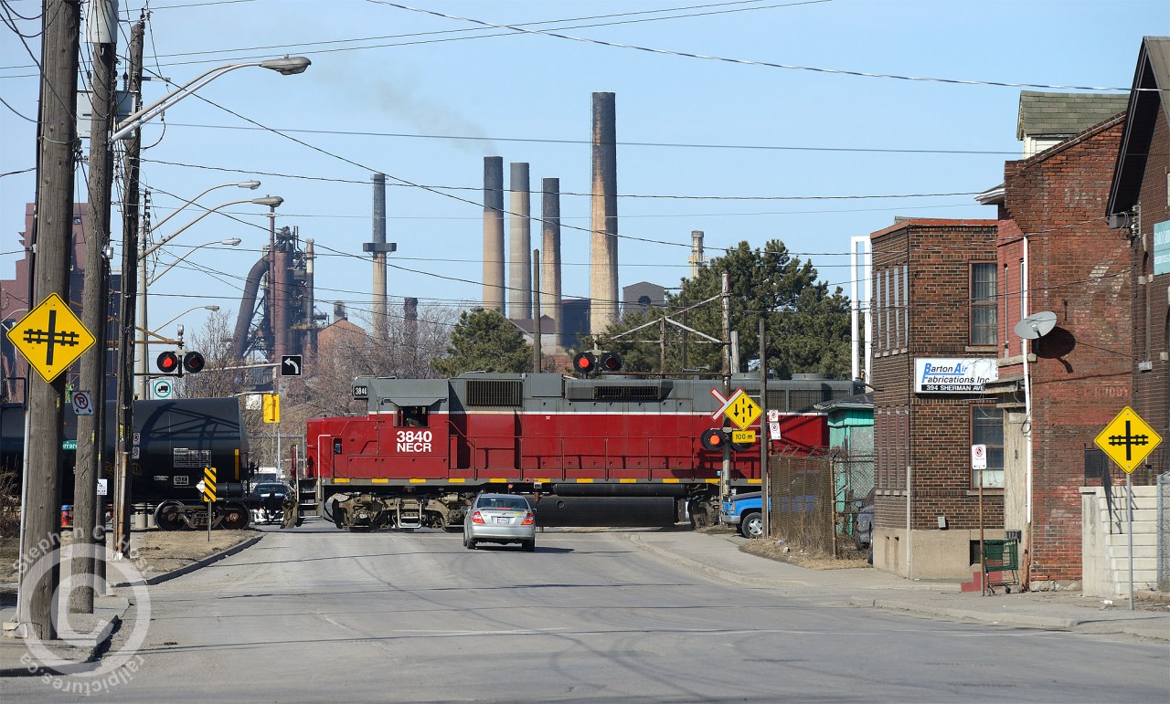 Stelco "E" Blast furnace looms large on Sherman Ave in Hamilton while SOR's 1400 Hamilton Yard job is heading down the N&NW spur with a long cut of about 30 cars.