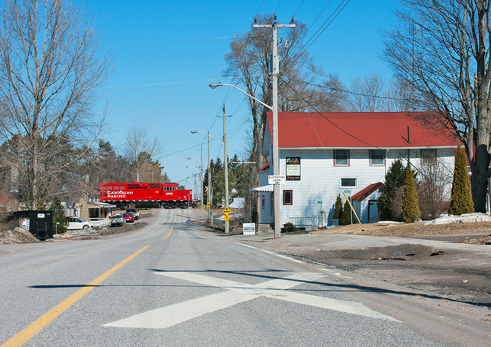 At Mile 148.11 of Canadian Pacific's Havelock Subdivision lies the quiet small town of Burketon, this mornings road switcher from Toronto makes the residences of the town known by blowing for the grade crossing at Old Scugog Road.