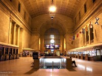 Just a quiet evening in the Great Hall, in downtown Toronto's Union Station. People departing on or arriving off trains congregating together, others buying tickets on late night departures at the VIA ticket wickets. Some sitting around waiting for their ride, be it a train or an automobile, others (like the photographer) enjoying a quiet moment before catching their GO bus home. The names of cities across the country adorn the 1920's stone walls near the high arched ceiling, and flags of the provinces and territories of Canada lining the north wall flap lazily with the odd wisp of air. All is quiet, all is calm. 21:13hrs.