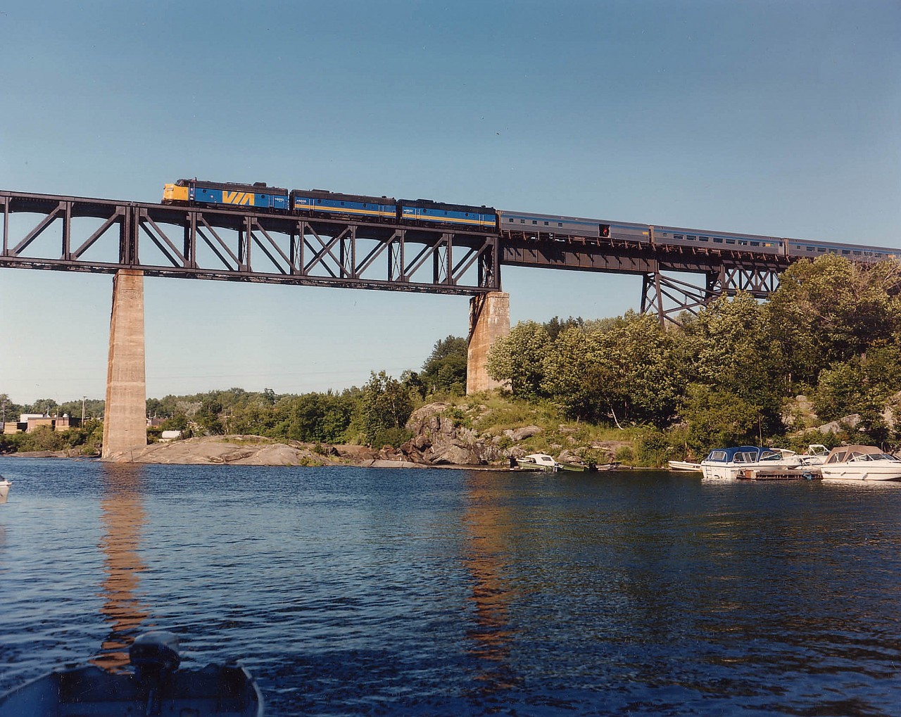 The northbound "Canadian" #9 rolls over the trestle at Parry Sound on a beautiful summer's day with VIA 6550, 6636 and 6632 the power. The leader has an interesting history; began as CP 4099 in 1953, then to CP 1400, to Nebkota as their #55, and back to CP 1400 in 1998 when it was painted up in tuscan and grey as well as being upgraded to an FP9 from an FP7. Unfortunately it was retired from active duty early in 2012.
