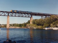 The northbound "Canadian" #9 rolls over the trestle at Parry Sound on a beautiful summer's day with VIA 6550, 6636 and 6632 the power. The leader has an interesting history; began as CP 4099 in 1953, then to CP 1400, to Nebkota as their #55, and back to CP 1400 in 1998 when it was painted up in tuscan and grey as well as being upgraded to an FP9 from an FP7. Unfortunately it was retired from active duty early in 2012.