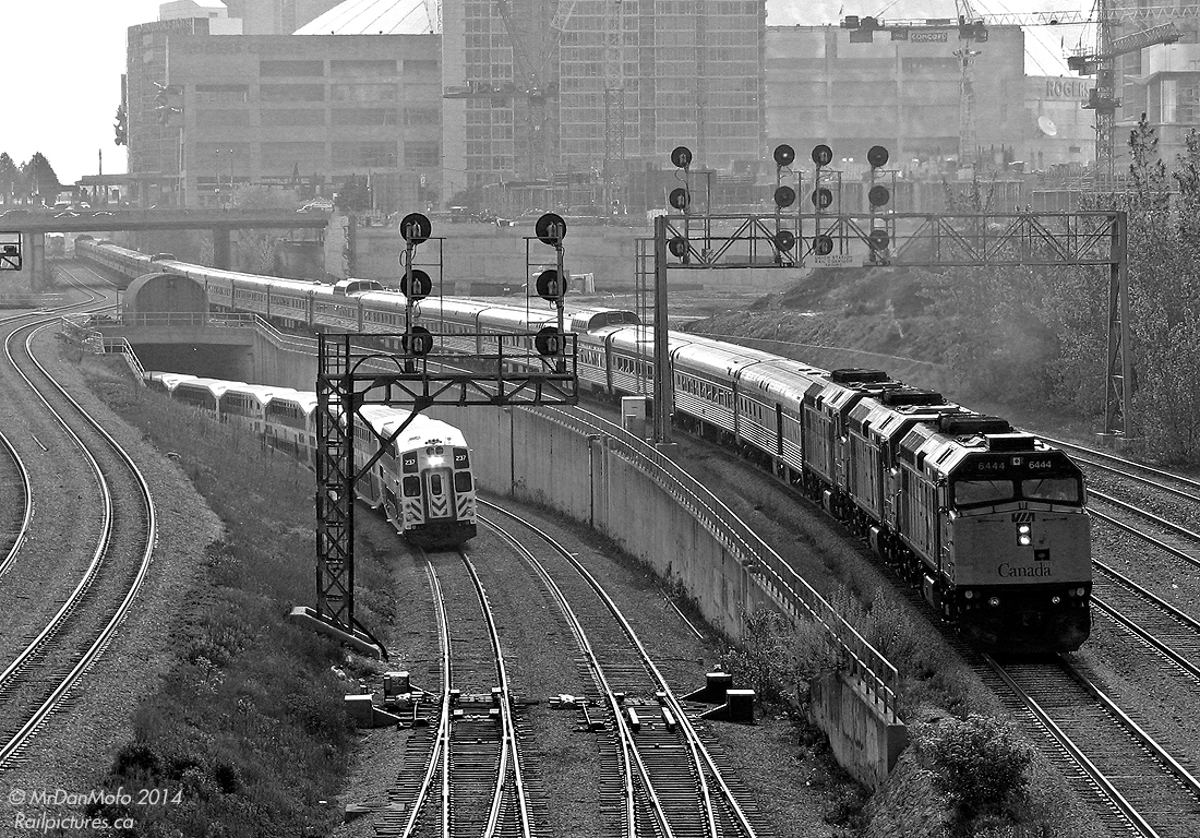 MONSTER CANADIAN  A mega monster of a 30-car summer Canadian consist threads its ways to Toronto's Union Station at Bathurst Street bridge, dwarfing the little 10 car GO trains puttering in and out of the corridor on a sunny morning just after 8am.  Today's consist featured 30 matching stainless steel Budd passenger cars including 5 domes, 7 Chateau sleepers, 12 Manor sleepers, 3 diners, 2 coaches and a baggage. 4 GMD F40PH-2 locomotives (3 on the head end, one on the rear) provided the power on this long train, whose rear end stretches all the way to Peter St. by the Skydome/Rogers Centre.  The train was so big they had to split it in two at Union Station to load it on two separate platforms, thus necessitating the F40 on the tail end to keep the other half of the train supplied with power when it was split.  After boarding and coupling both sections back together, the Canadian departed for Vancouver half an hour late, zipping past Bathurst St. again at 9:30am in a cloud of white 2-cycle EMD smoke.  More at Bathurst Street: The first rebuilt F40 on its maiden voyage west: http://www.railpictures.ca/?attachment_id=4210  New and Old GO power morning mingling: http://www.railpictures.ca/?attachment_id=11141 GO and VIA train mania after rush-hour: http://www.railpictures.ca/?attachment_id=11000