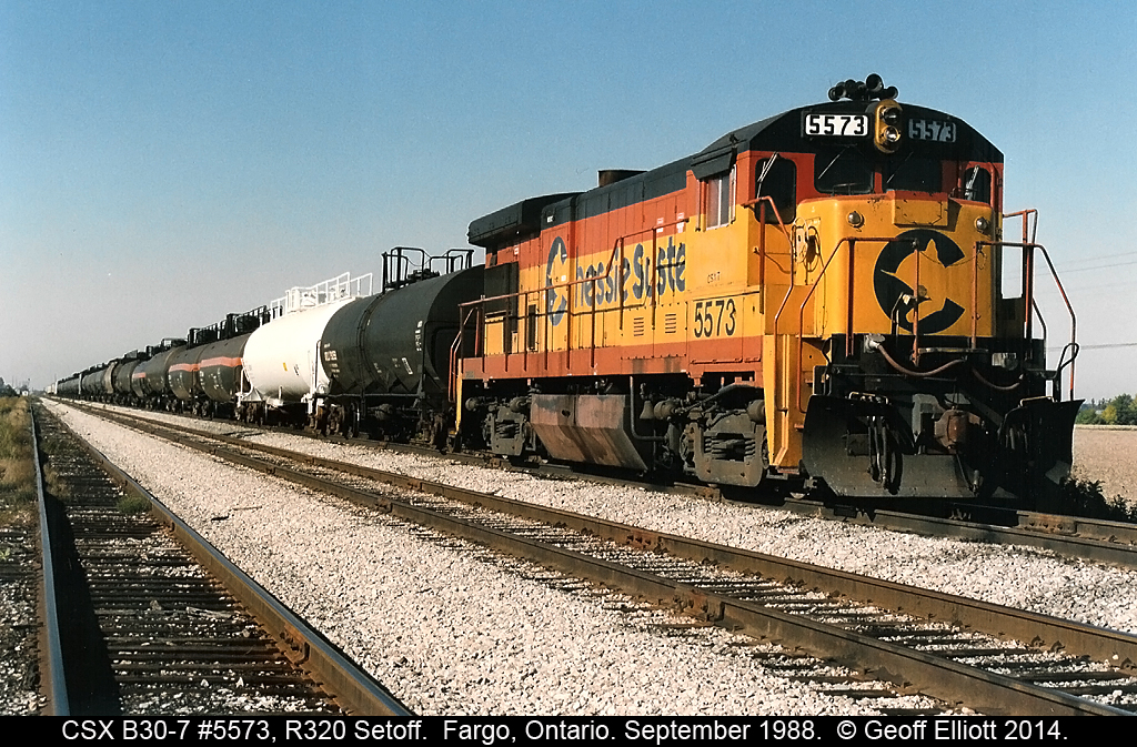 CSX B30-7 #5573 sits patiently in the north setoff track at Fargo, Ontario back in October of 1988.  5573 was setoff by CSX Train R320 as it moved across Southern Ontario on it's way to Buffalo from Detroit.  The cars behind 5573 will be lifted by the Local out of Chatham to move north, mostly to refineries in Sarnia.  When the local arrives it will bring cars for the westbound R321 to lift and place those in the south setoff.  R321 will also lift 5573 to use as additional power to make up for the extra tonnage they will lift in Fargo.  Today all that is left here are weeds....