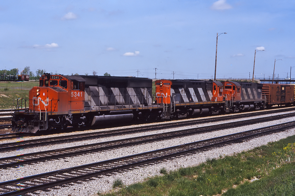 Cn has always been capable of some interesting lashups. 2 recently re-instated C424's(3209, 3228) tail out of Mac Yard with the standard 392 collection of UPFE reefers on the headend.