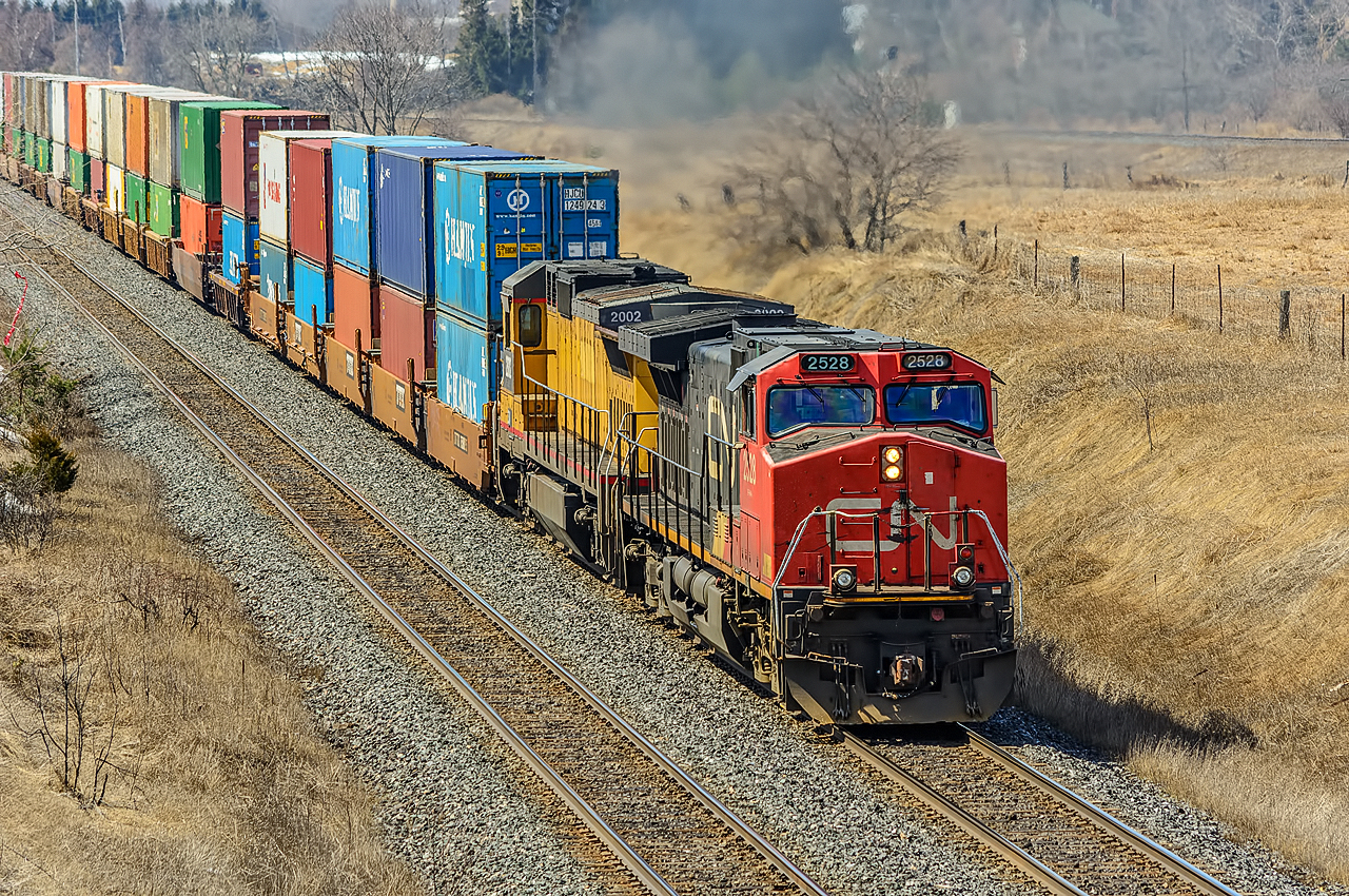 CN 2528 and 2002 eastbound with train 106 at Newtonville Road. The parallel running CP Belleville Sub can be seen near the top of the photo.