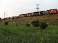 Backing their train up in the yard at last light, CN #115 with C44-9WL class-unit 2500 leads 5703 and 5518 at the south end of the sprawling Brampton Intermodal Yard, amidst the suburban foliage surrounding the strip-malls and plazas off Steeles Avenue.
