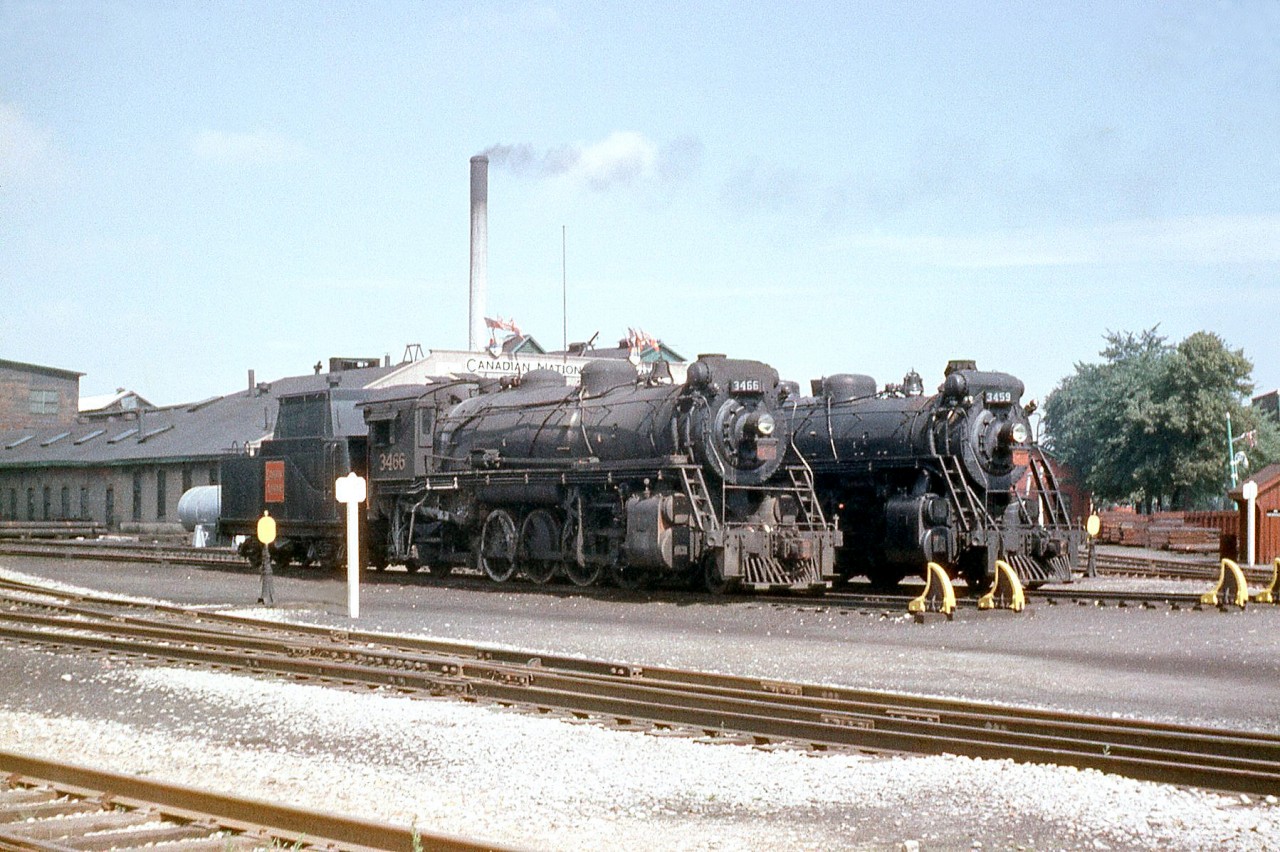 Canadian National 2-8-2 "Mikados" 3466 and 3459 rest outside CNR's famed steam locomotive shops in Stratford ON, in 1958. These had previously been converted into oil burners for Western Canada. Both were built by MLW as part of the S1f class in 1913, and by 1958 their time was nearly up: they would be scrapped in 1959 and 1961 respectively.

The CN's Stratford backshops, built for the GTR in 1908 for heavy overhauls and maintenance of its steam locomotive fleet, didn't fit in with CN's plans to dieselize its operations and were officially closed on March 31st, 1964. After surviving a few different owners and even a fire, the City of Stratford acquired the former shop buildings in 2010.