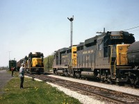 And if you thought 3 GP30's was something, here's 5! Chesapeake and Ohio GP30 3007 trails another sister on a westbound freight over Subdivision 1, meeting the eastbound with <a href=http://www.railpictures.ca/?attachment_id=14844><b>3021 leading two others pictured before</b></a>, which is waiting in front of the C&O station at Merlin ON. All these units weren't but a year or two old at the time of this photo. Also note the station semaphore signals, old grain elevator and shed in the background, maintenance equipment on the siding track and the two fellows watching all the action.