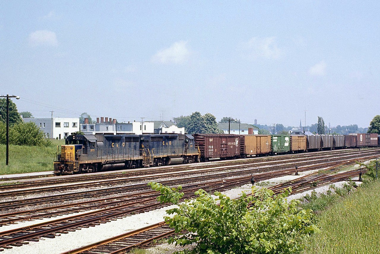 A Chesapeake and Ohio freight, bound for St. Thomas, leaves Fort Erie ON heading westbound. C&O GP35 3573 and a GP38 are the power, with train of American-road freight cars from the states including those from the Pennsylvania RR, Detroit, Toledo and Ironton, Burlington Northern, and Norfolk & Western.