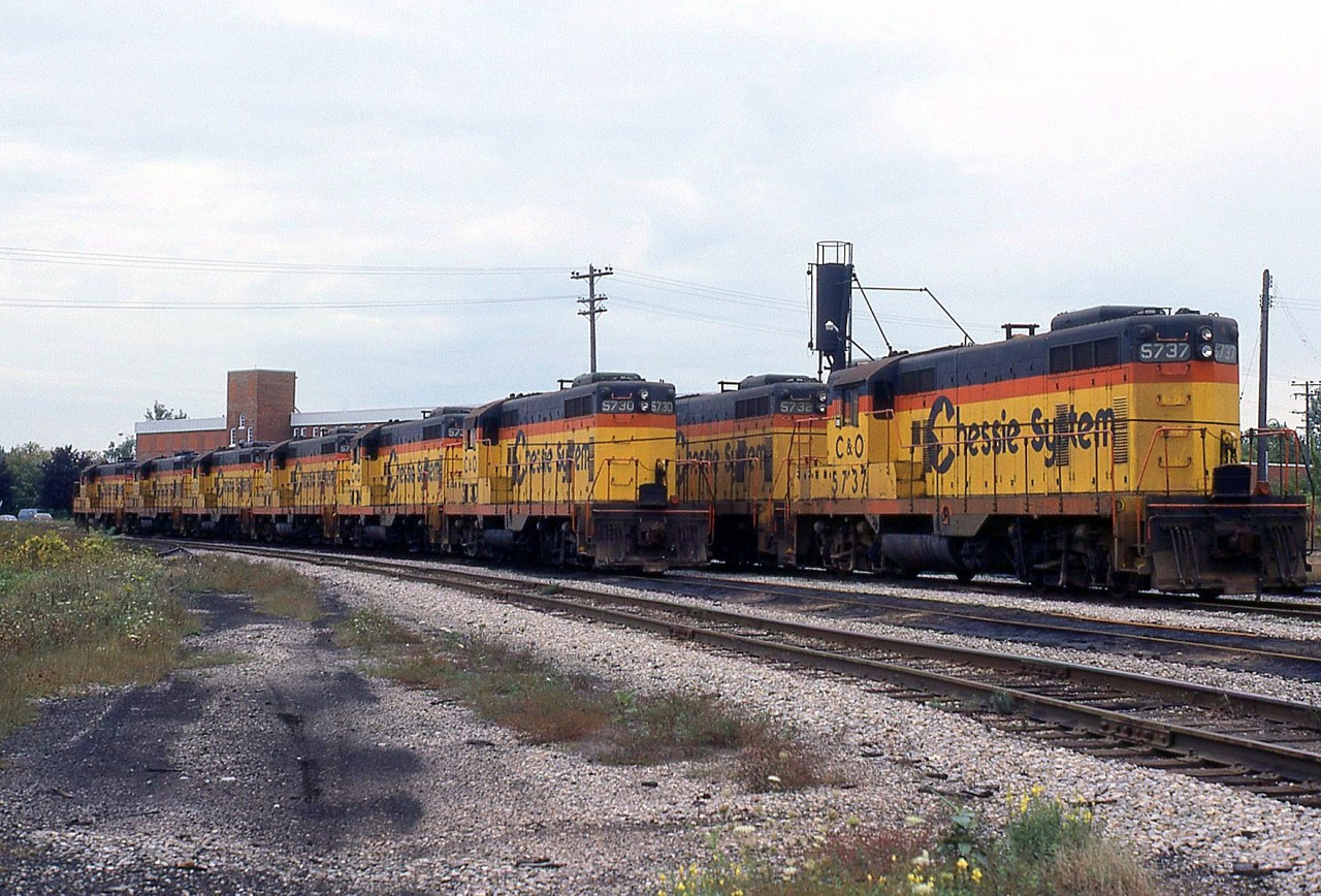 A large group of first Generation Geeps, the GP7's that killed steam in the 50's, sit stored and out of service at Chesapeake and Ohio's roundhouse/shops off Wilson Ave. in St. Thomas ON. Some of the units visible are C&O 5737, 5732 and 5730, all in matching Chessie System paint with their long hood doors secured, deemed surplus by their owner. Most were sold off ending up on shortlines and regionals.Also worthy of noting is these particular units are Canadian-production (GMDD) GP7's, built in London ON for the C&O in 1951.